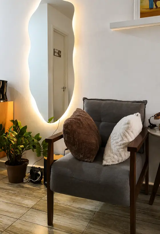 Recepção do consultório com poltrona e espelho iluminado